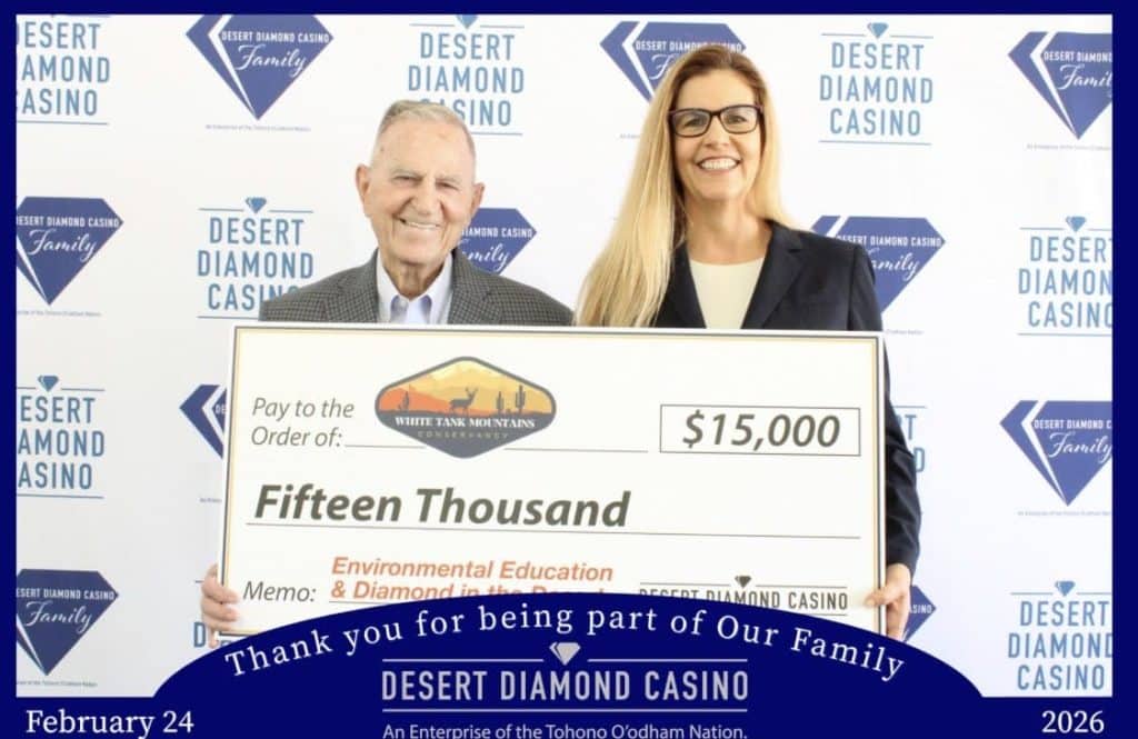 Two people holding a $15,000 donation check to White Tank Mountains Conservancy from Desert Diamond Casino